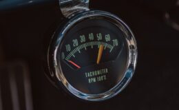 A car dashboard with a speedometer and gauge